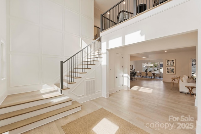 foyer entrance with hardwood / wood-style flooring and a high ceiling