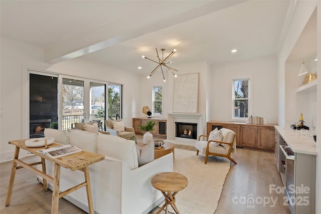 living room featuring wine cooler, light wood-type flooring, and an inviting chandelier