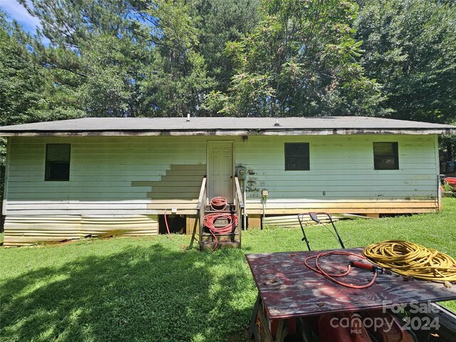 rear view of property with a yard