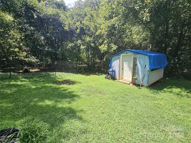 view of yard featuring a storage shed, an outbuilding, and fence