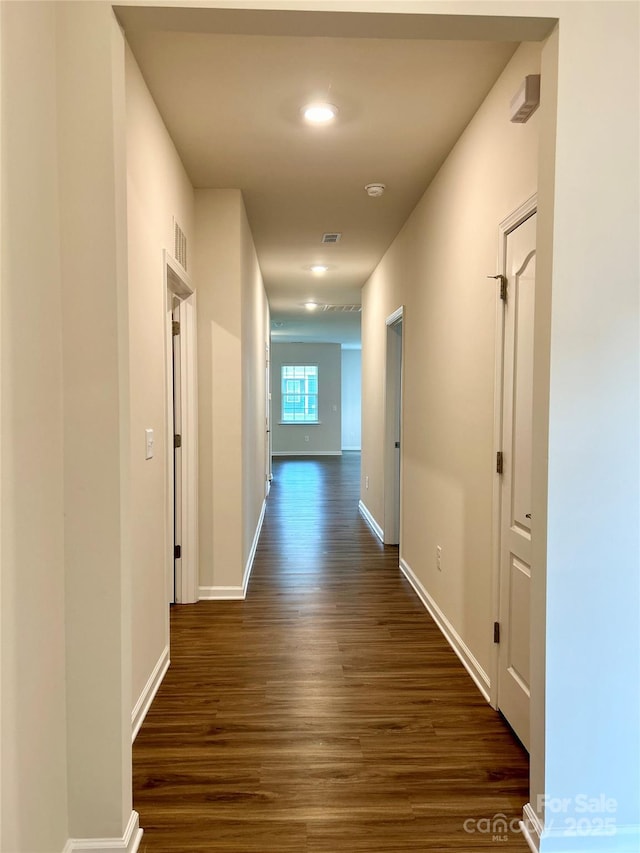 corridor with dark hardwood / wood-style flooring