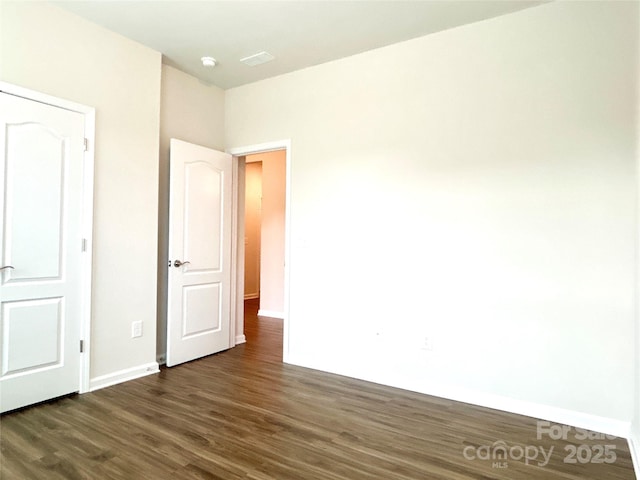 unfurnished bedroom with dark wood-type flooring