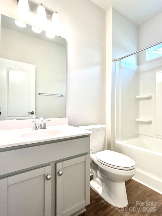 full bathroom featuring vanity, toilet, wood-type flooring, and bathtub / shower combination