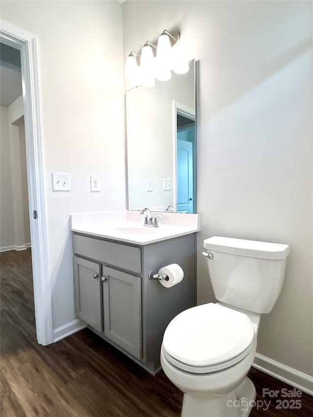 bathroom featuring wood-type flooring, vanity, and toilet