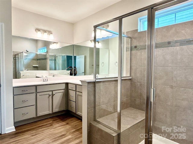 bathroom featuring hardwood / wood-style floors, vanity, and a shower with door