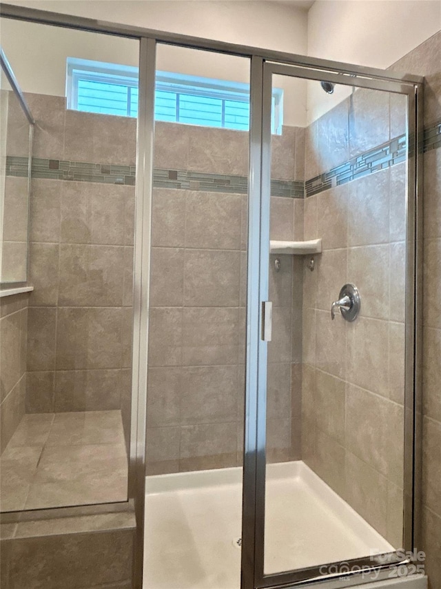 bathroom featuring a shower with shower door