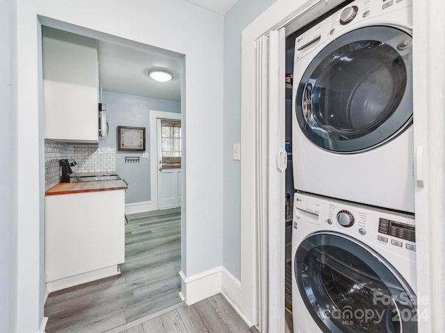 clothes washing area with stacked washing maching and dryer and light hardwood / wood-style floors