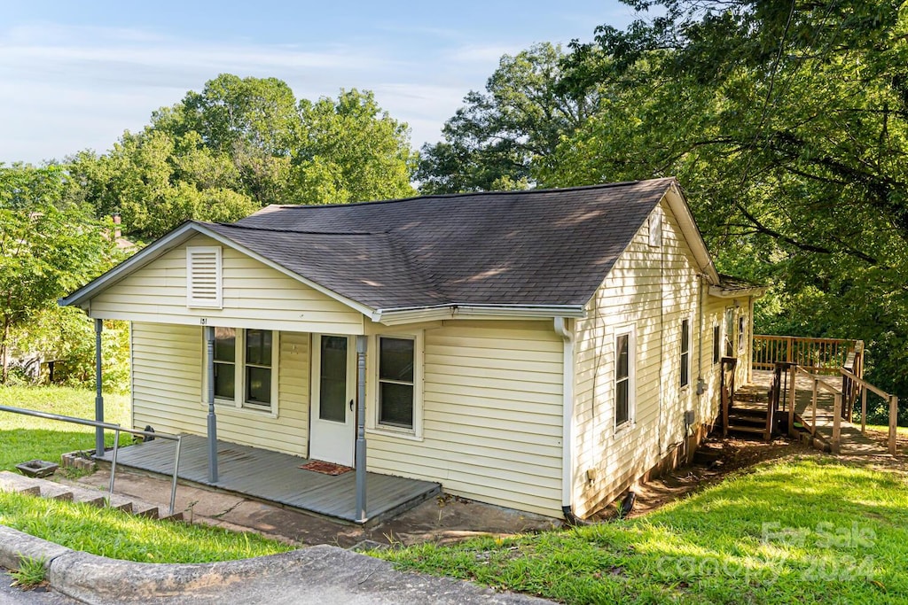 view of front of home with a front lawn and a wooden deck