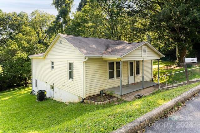 exterior space with central AC unit and a lawn