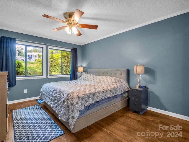 bedroom with hardwood / wood-style floors, crown molding, a textured ceiling, and ceiling fan