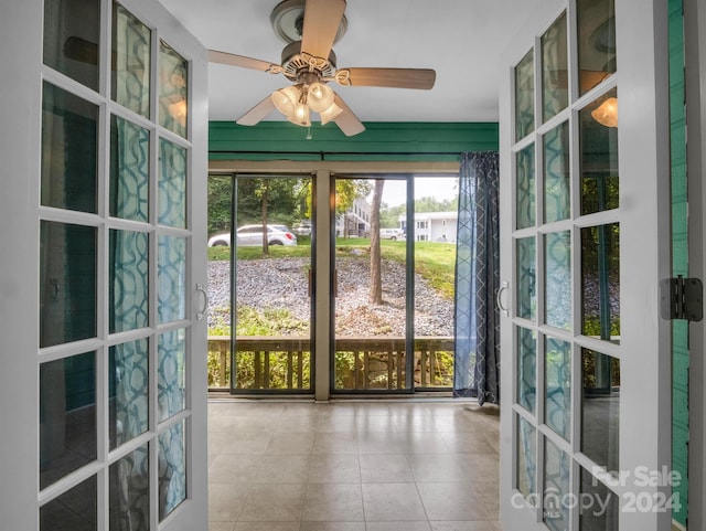 unfurnished sunroom featuring ceiling fan