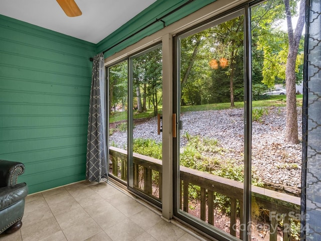 unfurnished sunroom featuring ceiling fan