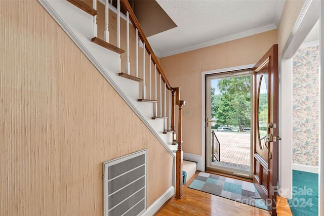 entryway featuring wood-type flooring and ornamental molding