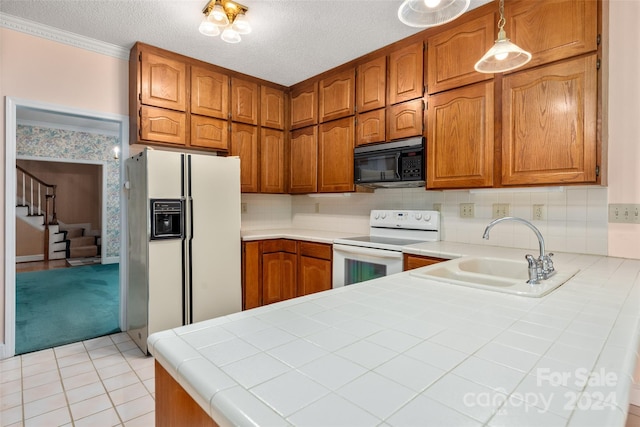 kitchen with a textured ceiling, white appliances, tile countertops, and sink