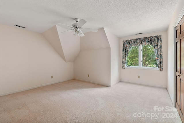 bonus room featuring a textured ceiling, ceiling fan, light colored carpet, and vaulted ceiling