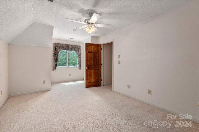 bonus room with a textured ceiling, light colored carpet, vaulted ceiling, and ceiling fan