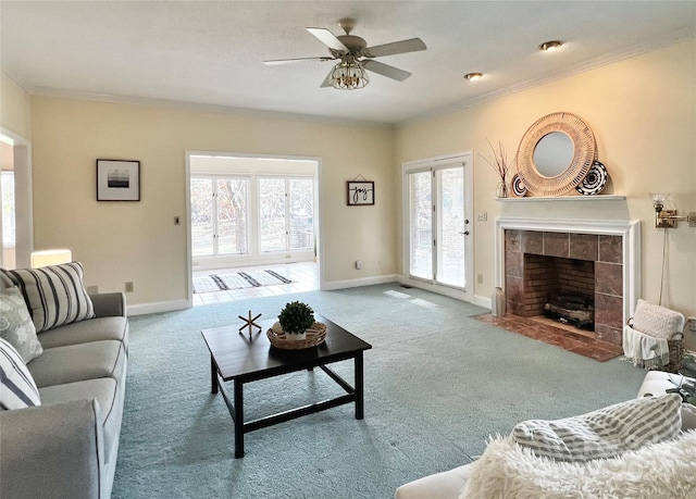 carpeted living room featuring a fireplace, ceiling fan, and ornamental molding