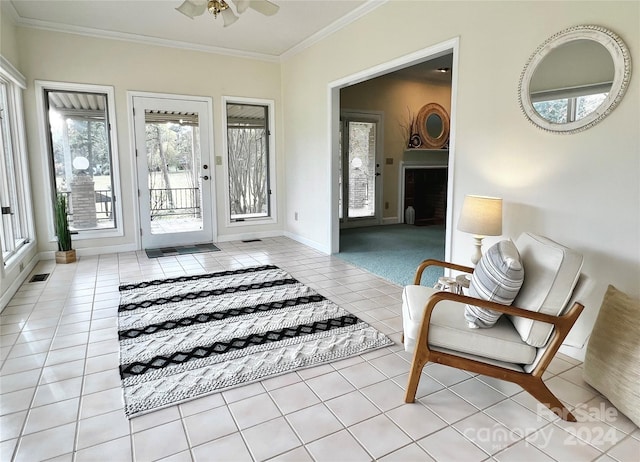 sitting room with ceiling fan, light tile patterned floors, and ornamental molding