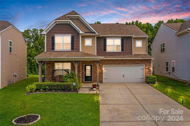 craftsman house featuring a garage and a lawn