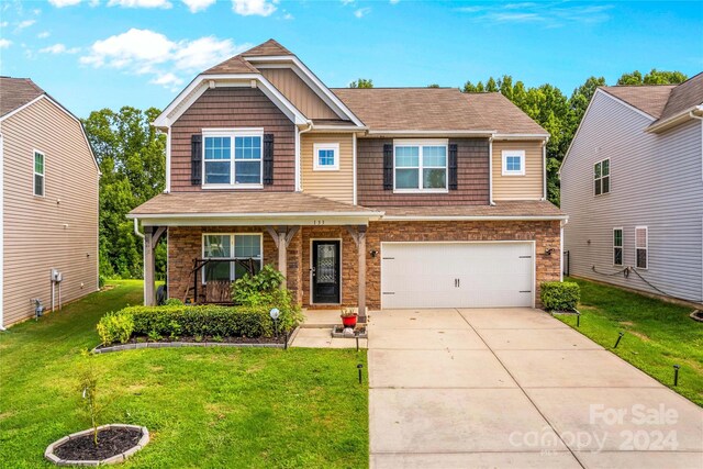 craftsman house with a front lawn and a garage