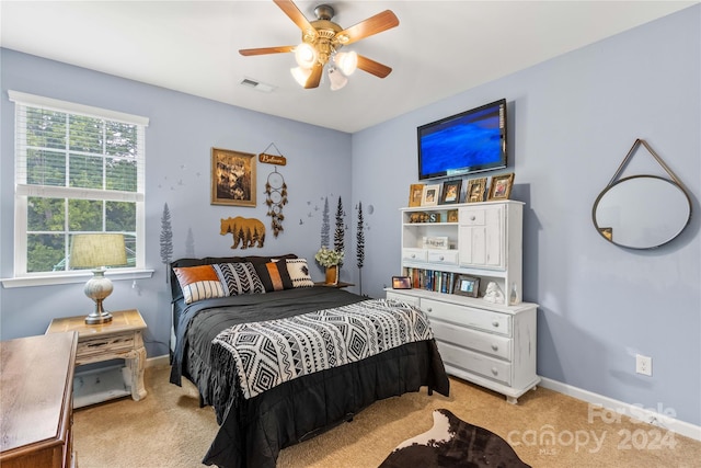 bedroom featuring ceiling fan, visible vents, baseboards, and light colored carpet