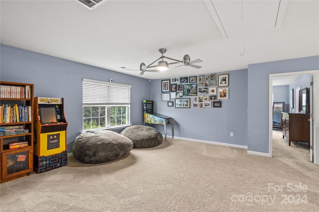 sitting room with visible vents, attic access, light carpet, ceiling fan, and baseboards