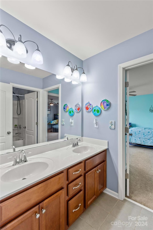 full bathroom featuring ensuite bathroom, double vanity, tile patterned flooring, and a sink