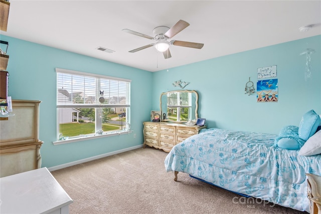 bedroom featuring baseboards, ceiling fan, visible vents, and light colored carpet