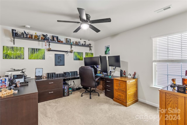 home office with ceiling fan, baseboards, visible vents, and light colored carpet