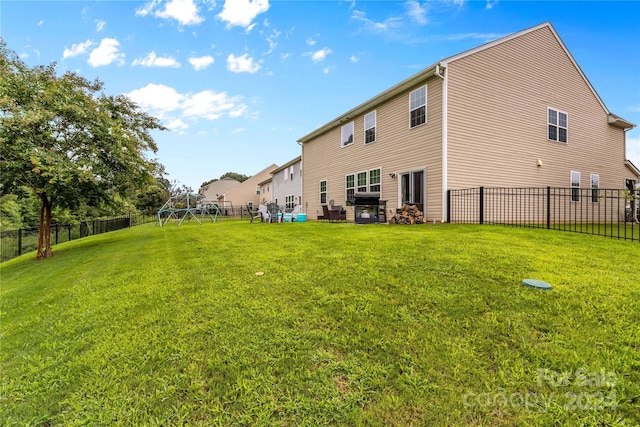 back of property featuring a yard and a fenced backyard