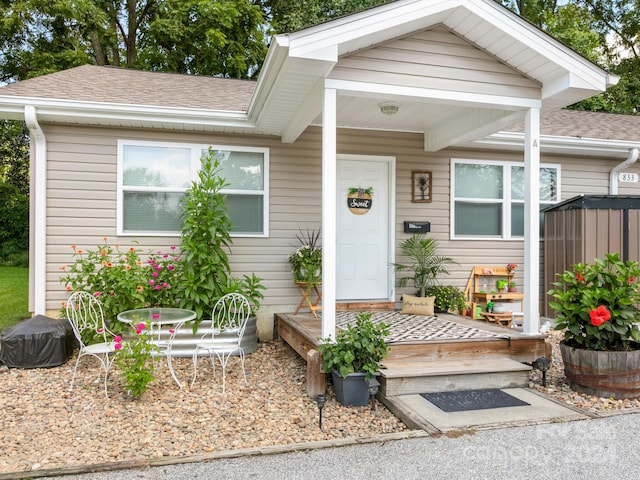 view of front of home with outdoor dining space and roof with shingles