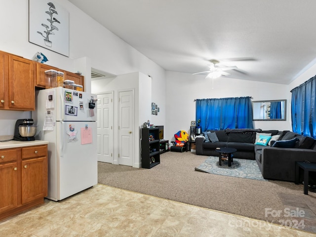 living area featuring light carpet, vaulted ceiling, and a ceiling fan