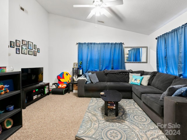 carpeted living room featuring vaulted ceiling, a textured ceiling, visible vents, and a ceiling fan