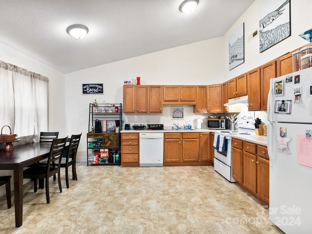 kitchen featuring brown cabinets, white appliances, light countertops, and under cabinet range hood