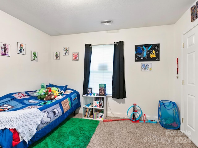 bedroom featuring a textured ceiling, carpet floors, visible vents, and baseboards