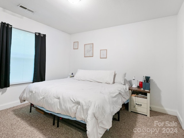 bedroom with carpet, visible vents, and baseboards