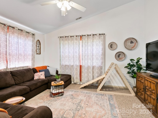 living area with visible vents, vaulted ceiling, and ceiling fan