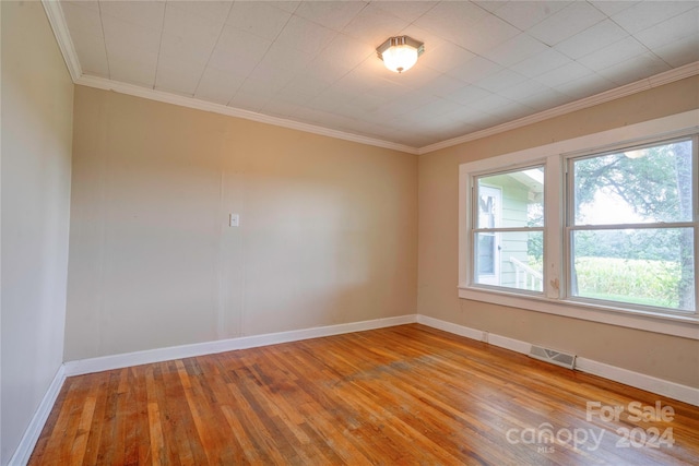 spare room with light hardwood / wood-style flooring and crown molding