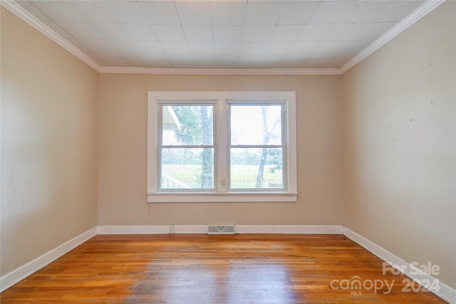 spare room featuring crown molding and light hardwood / wood-style flooring