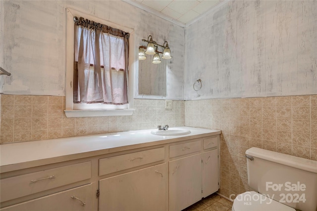 bathroom with tile walls, vanity, and toilet