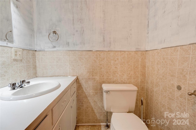 bathroom with tile walls, vanity, and toilet