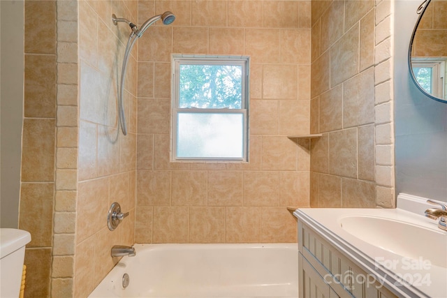 full bathroom featuring vanity, tiled shower / bath combo, and toilet