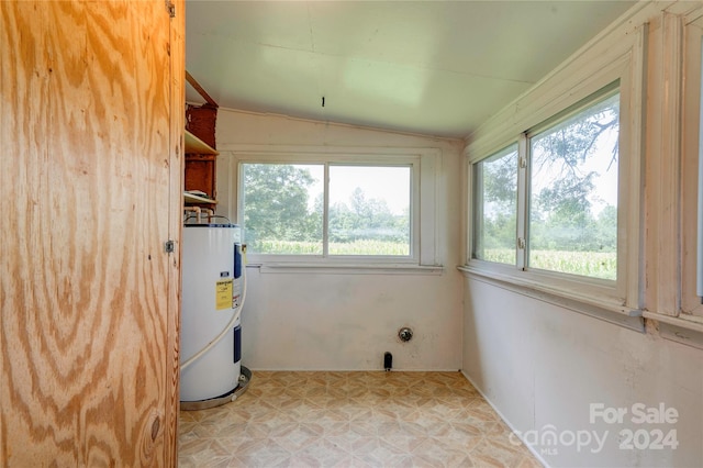 clothes washing area with a wealth of natural light and electric water heater