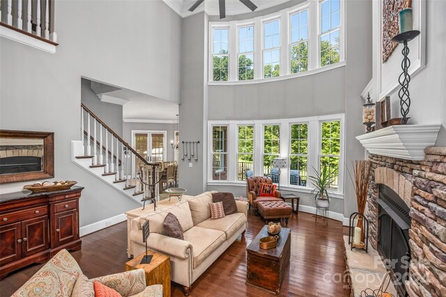 living room with a high ceiling, dark hardwood / wood-style flooring, ceiling fan, and a wealth of natural light