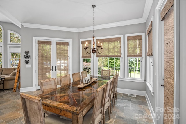 dining space with crown molding, dark tile patterned floors, and an inviting chandelier