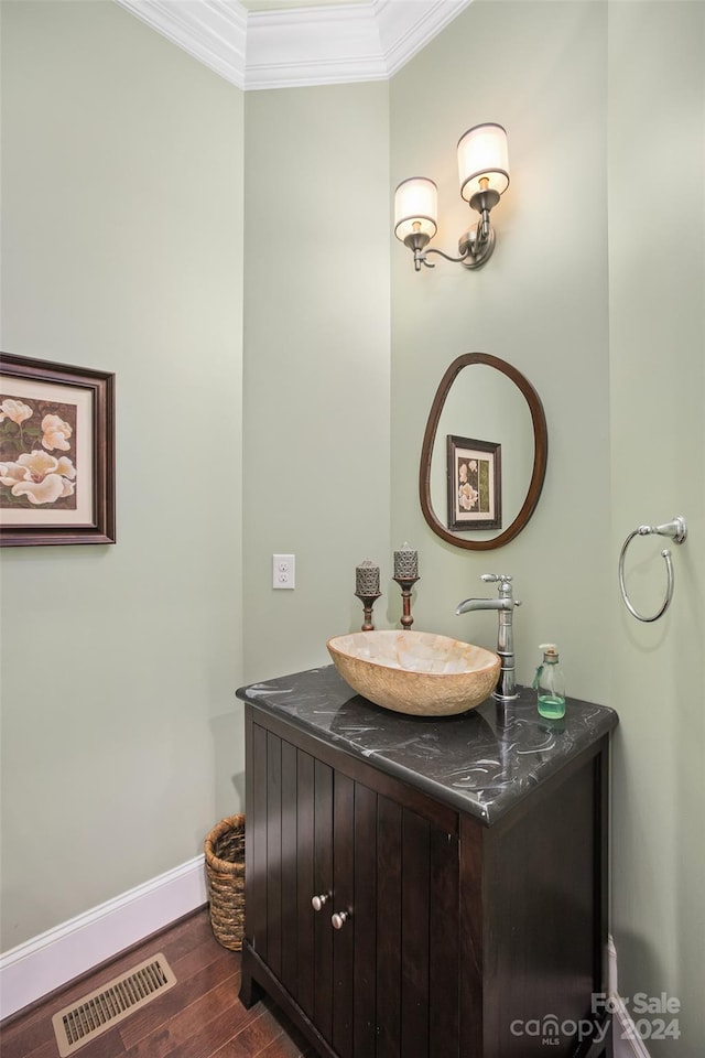 bathroom with crown molding, vanity, and hardwood / wood-style flooring