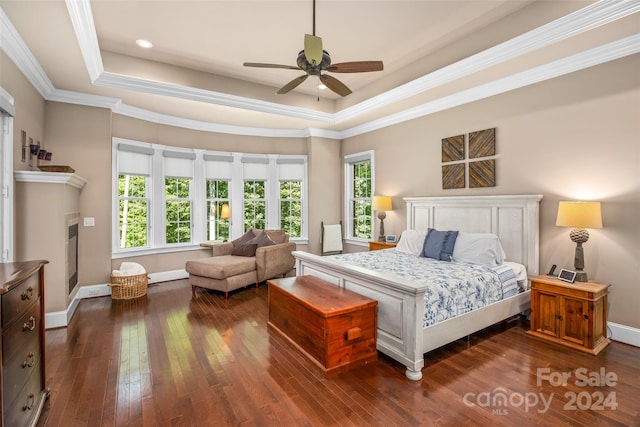 bedroom with ceiling fan, crown molding, a raised ceiling, and dark hardwood / wood-style floors