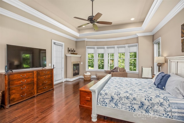 bedroom with ceiling fan, crown molding, dark hardwood / wood-style flooring, and a tray ceiling