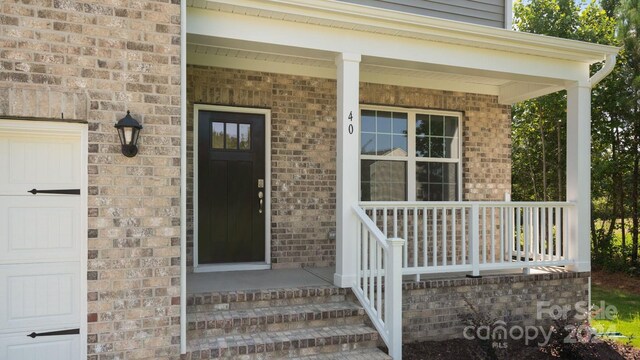 property entrance with covered porch and a garage