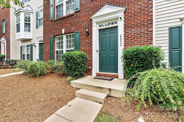 entrance to property featuring brick siding